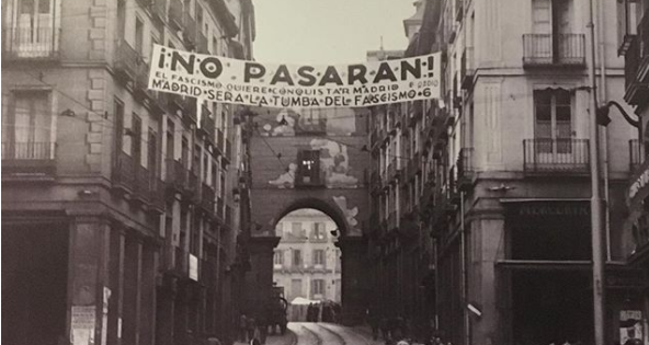 Fotografia histórica. Em Madrid, uma faixa estendida entre dois prédios, com a frase !No Pasaran! (Não passarão)