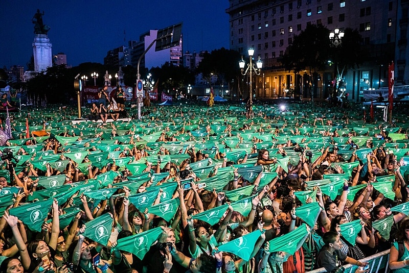 centenas de mulheres erguem lenços verdes, em praça de Buenos Aires