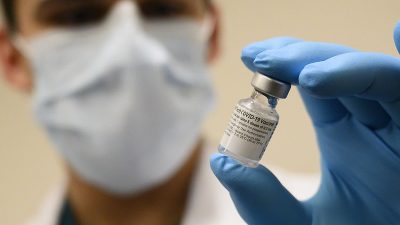 Um profissional de saúde exibe uma dose de uma vacina