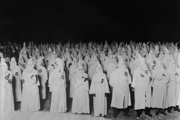 Homens com uniforme e capuz da KKK
