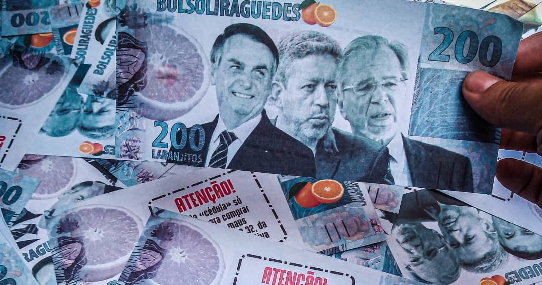 Imagem de uma nota de dinheiro de R$ 200 feita pelos manifestantes. A nota traz as fotos de Bolsonaro, Lira e Guedes. Acima está escrito BOLSOLIRAGUEDES. Ao lado a imagem de uma laranja.