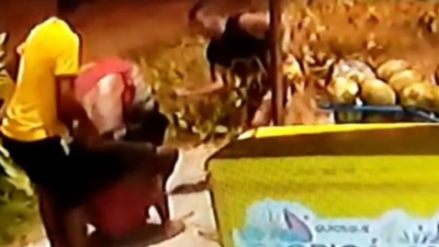 Cena do vídeo da câmera de segurança, com homens atacando Moise, que está no chão.