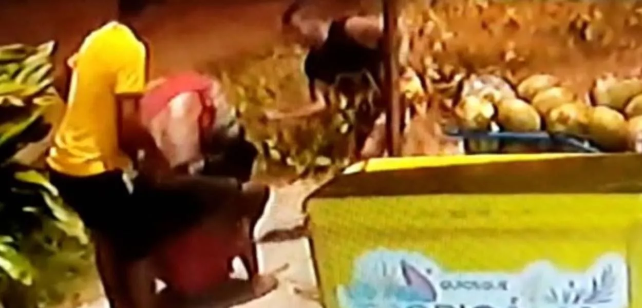 Cena do vídeo da câmera de segurança, com homens atacando Moise, que está no chão.