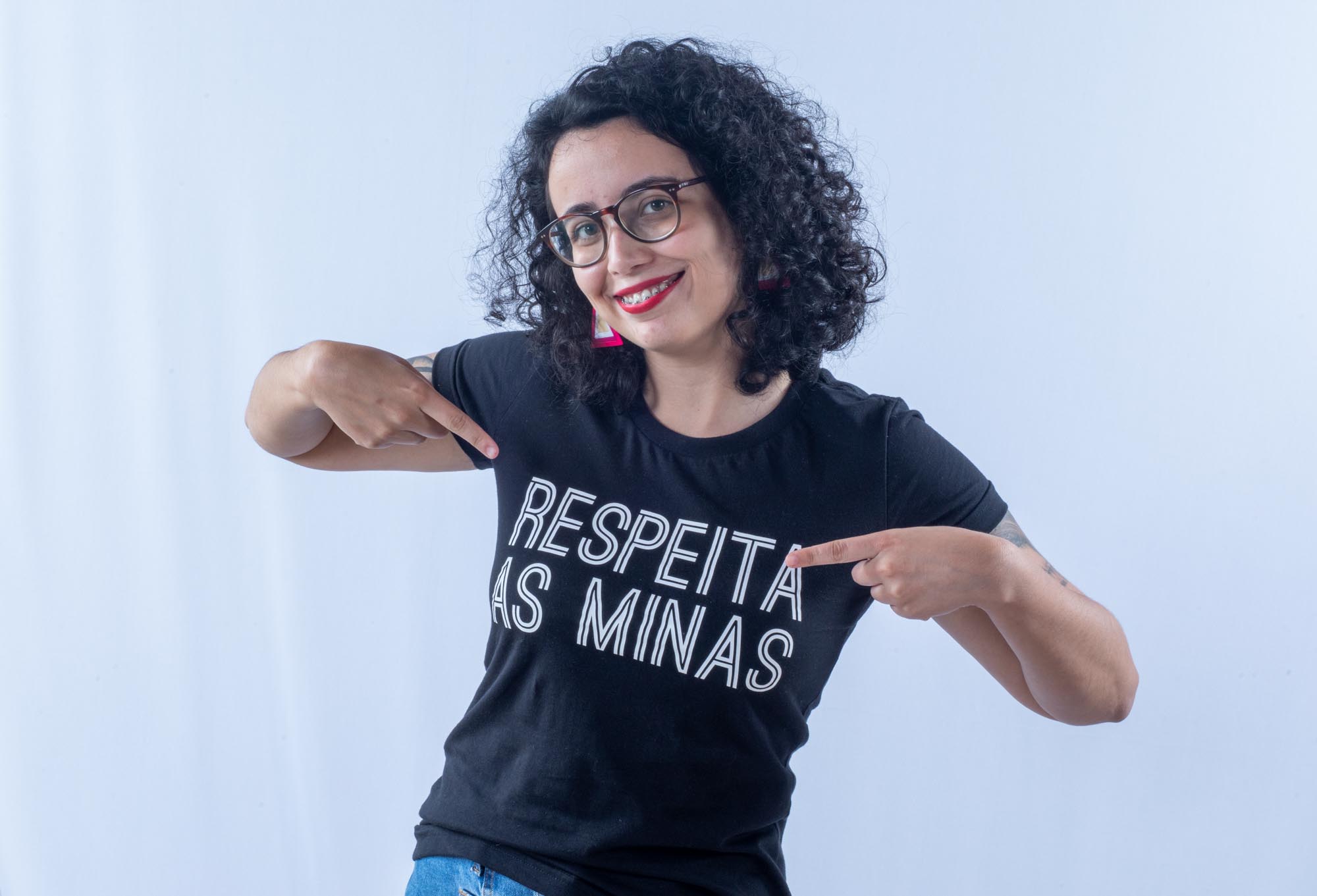 foto de uma mulher com camisa preta com letras brancas, onde se lê: "Respeita as minas"