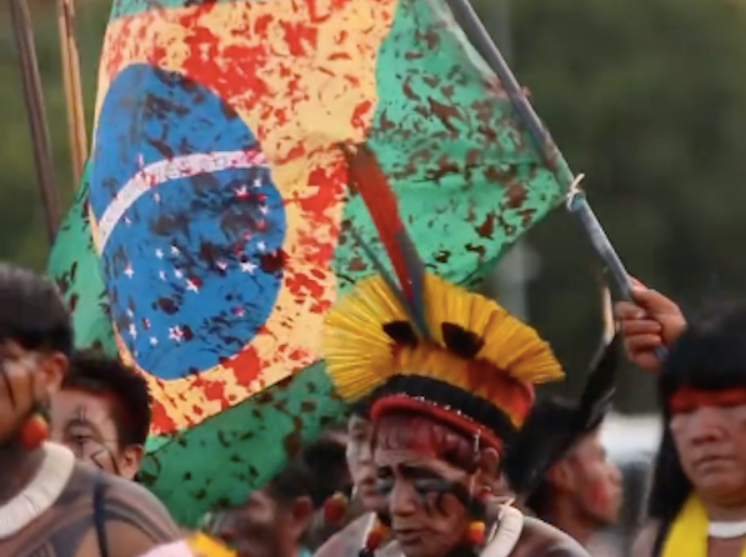 bandeira com simulação de sangue em manifestação a favor dos povos indígenas