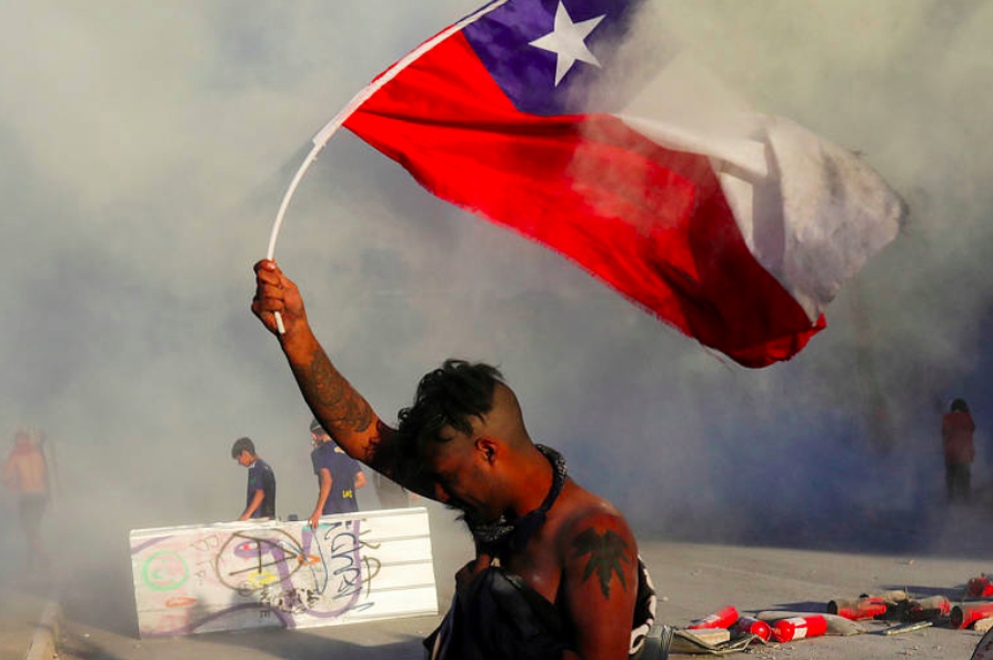 Manifestante segura bandeira chilena durante protesto